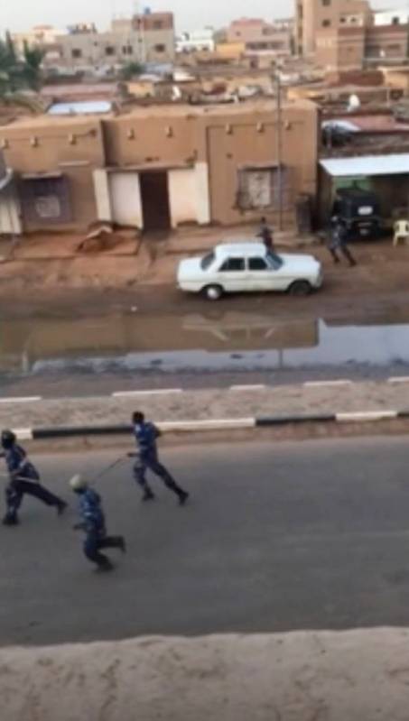 In this image made from video, Police officers running down a street in Khartoum, Sudan, on Mon ...