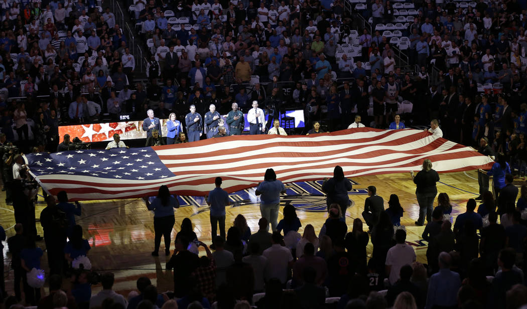 FILE - In this Wednesday, Oct. 26, 2016 file photo, first responders hold a flag on the court a ...