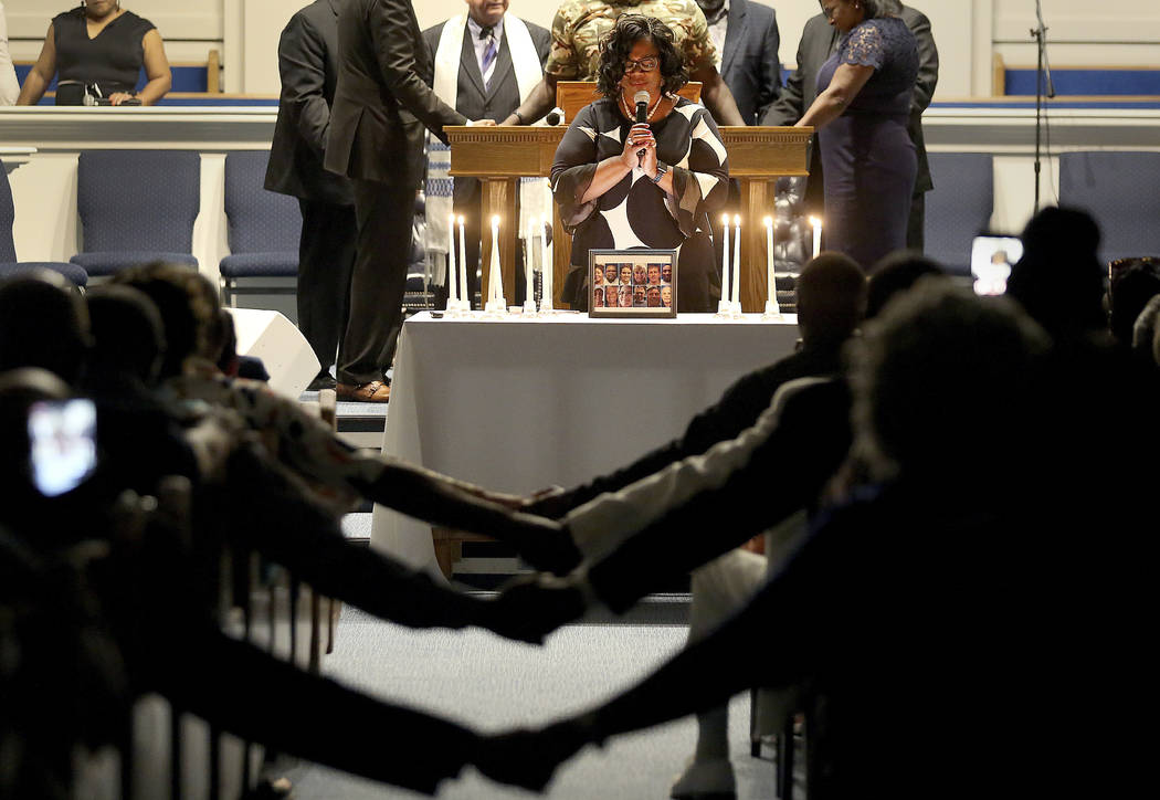 After lighting 12 candles, Veronica Coleman leads the congregation in prayer during a vigil for ...