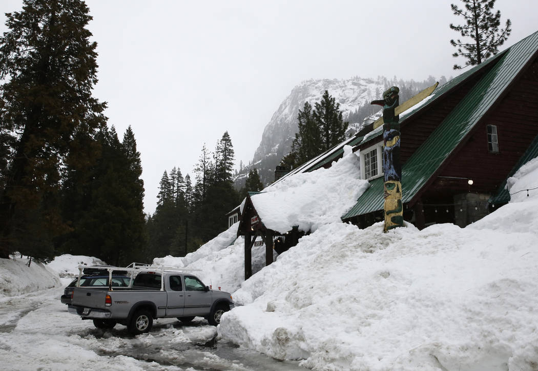 In this Feb. 28, 2019, file photo, snow, from storms is piled up as high as the eves of the Str ...