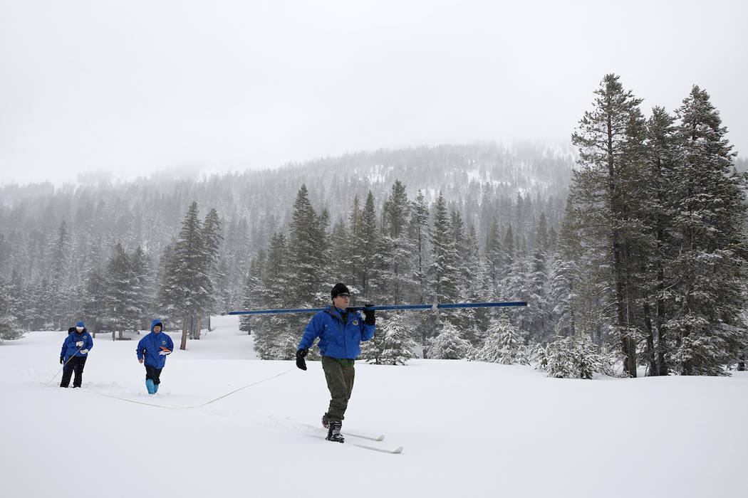 In this Feb. 28, 2019, file photo, John King, right, of the Department of Water Resources, carr ...