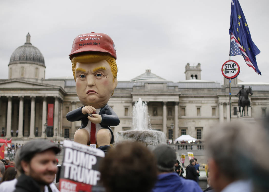 Large puppet portraying Donald Trump is carried as people gather in Trafalgar Square, central L ...