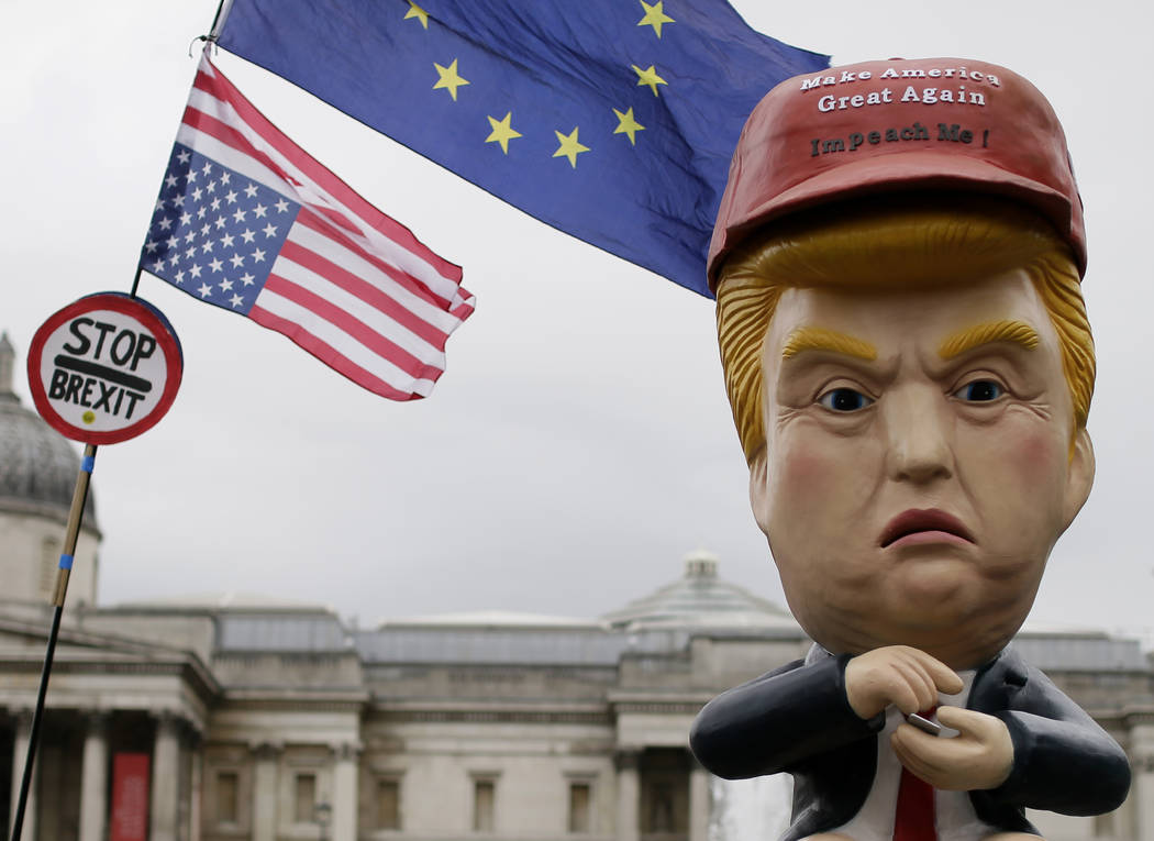 Large puppet portraying Donald Trump is carried as people gather in Trafalgar Square, central L ...