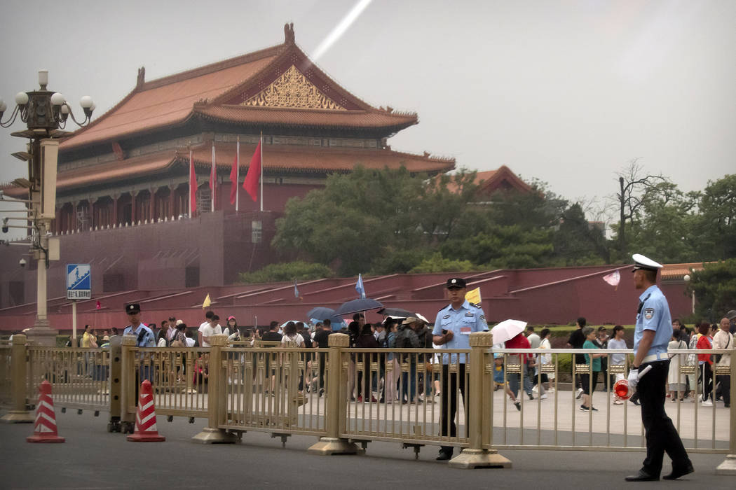 Security officials stand guard in front of Tiananmen Gate next to Tiananmen Square in Beijing, ...