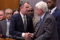 Virginia Gov. Ralph Northam , center, shakes the hand of Virginia Beach (Va.) Mayor Bobby Dyer ...