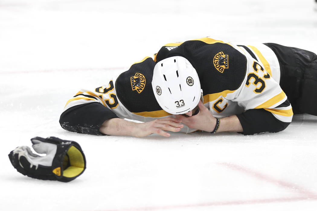 Boston Bruins defenseman Zdeno Chara, of Slovakia, lies on the ice after getting hit in the fac ...