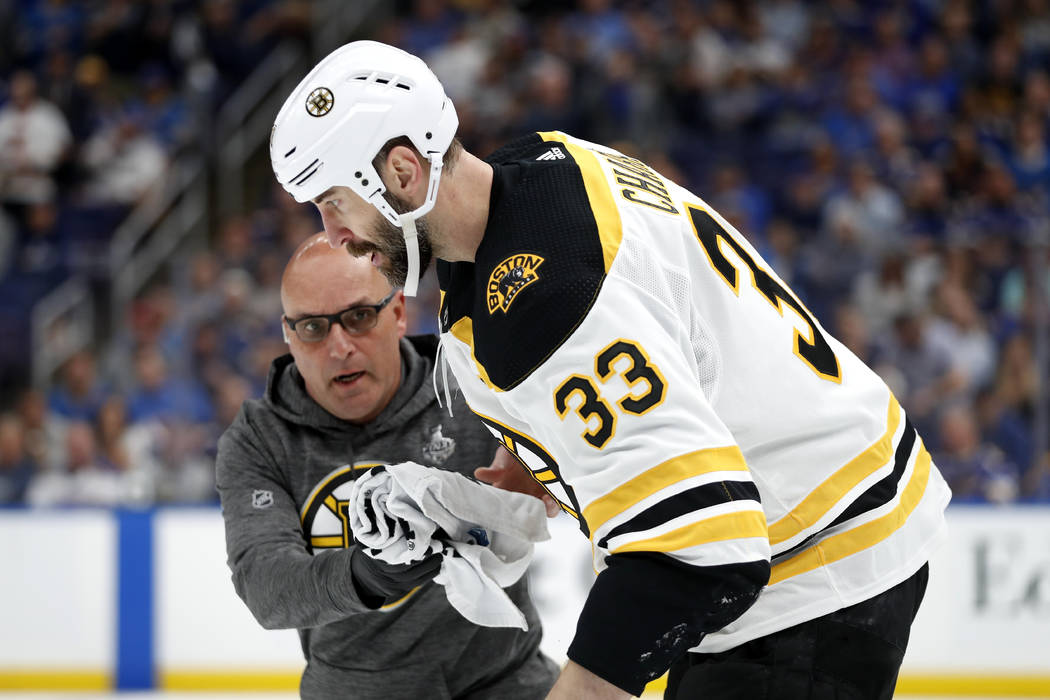 Boston Bruins defenseman Zdeno Chara (33), of Slovakia, is helped off the ice after getting hit ...