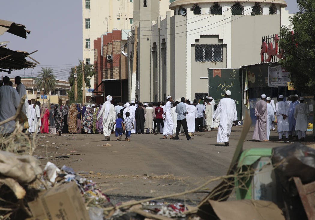 Worshippers gather at a mosque behind a roadblock set by protesters on a main street in the Sud ...