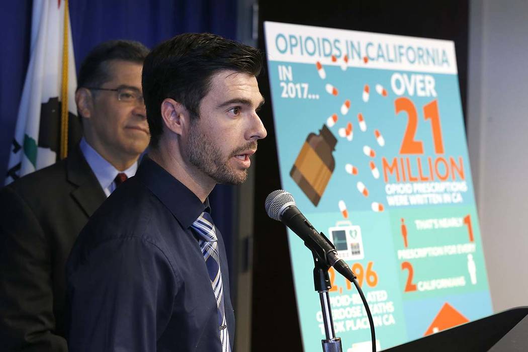 Jordon Basileu, right, flanked by California Attorney General Xavier Becerra, left, discusses h ...