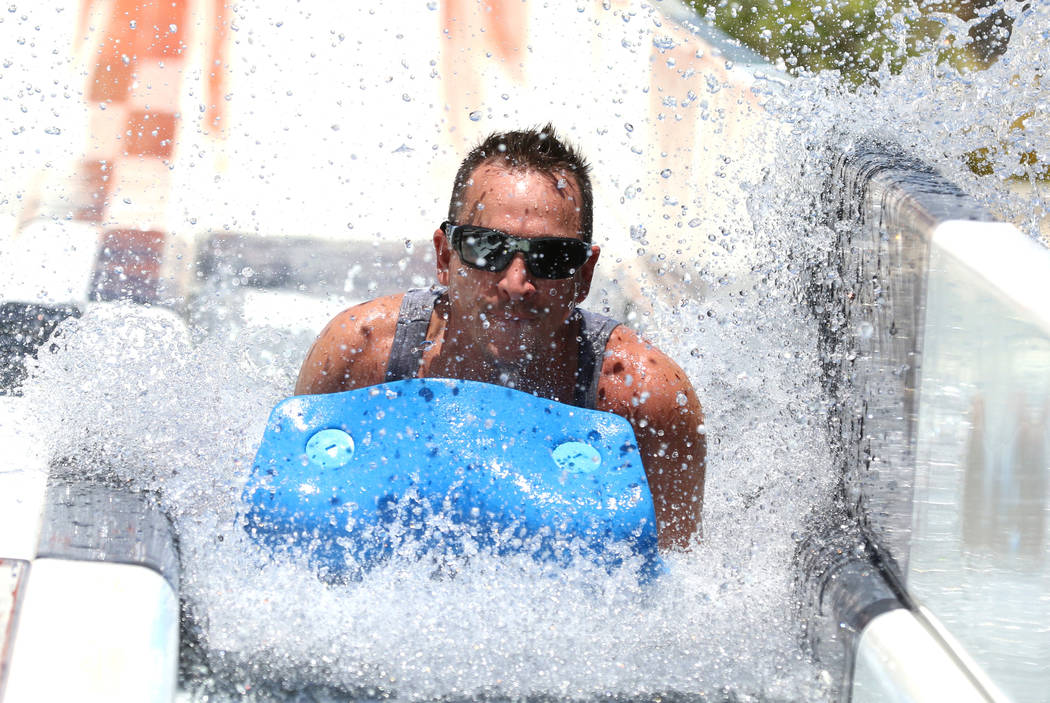 Liberty High School teacher John Cress splashes as he rolls down a water slide at Cowabunga Bay ...