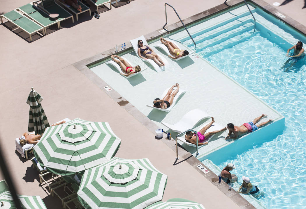 Hotel guests relax by the pool at Park MGM as temperatures reach 100 degrees in the Las Vegas V ...