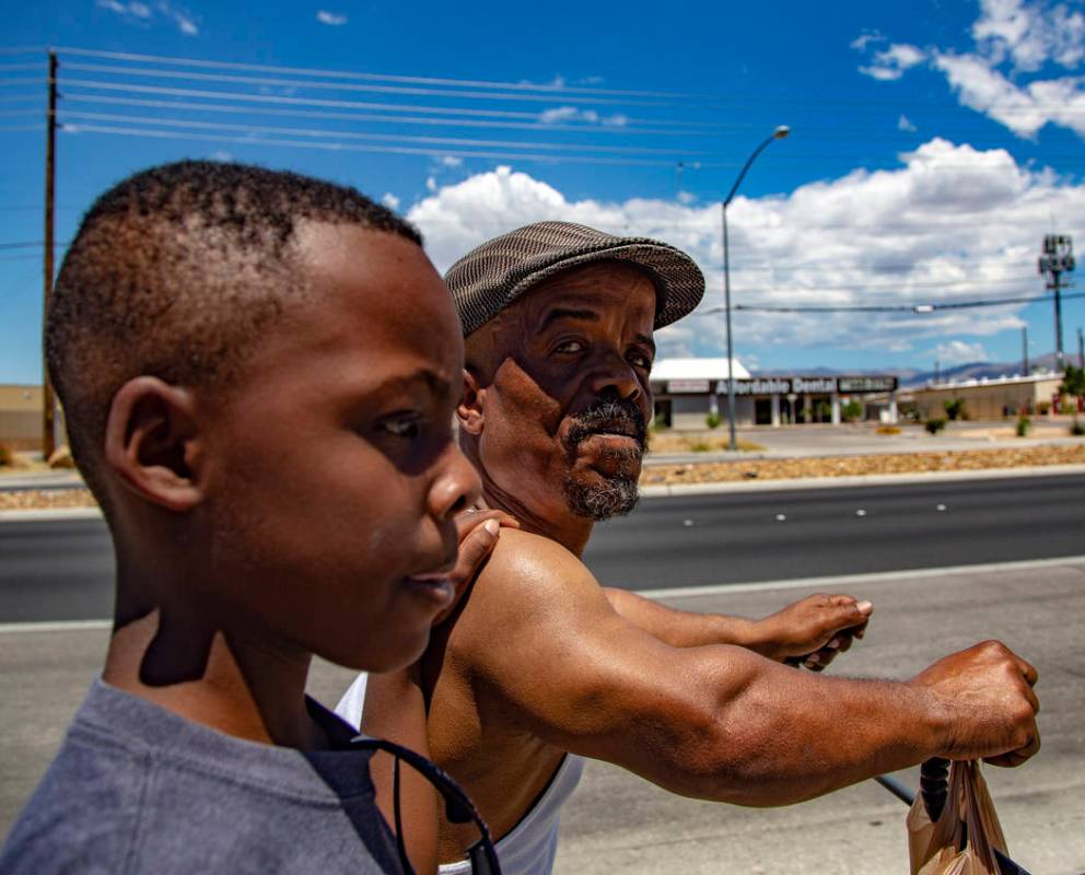 Emmanuel Worthington, 58, of North Las Vegas walks back home with his Grandson, Jaiden Jackson, ...