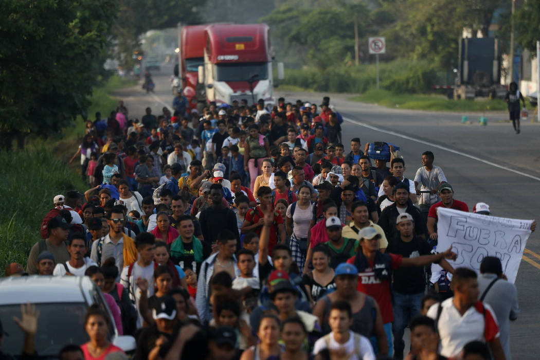 Hundreds of Central American migrants walk together on the highway, after crossing the Guatemal ...