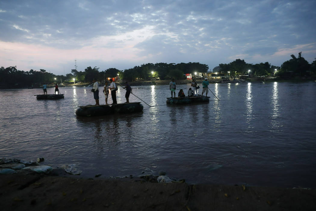 Migrants on rafts cross the Suchiate river on the Guatemala – Mexico border, near Ciudad ...