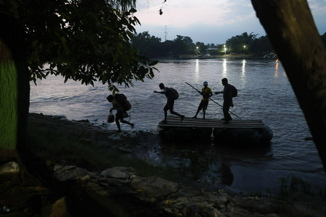 Migrants on rafts reach the Mexico shore after crossing the Suchiate river on the Guatemala &#x ...