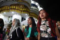 Young women pray outside the "La Luz Del Mundo," or Light of the World church, after members le ...