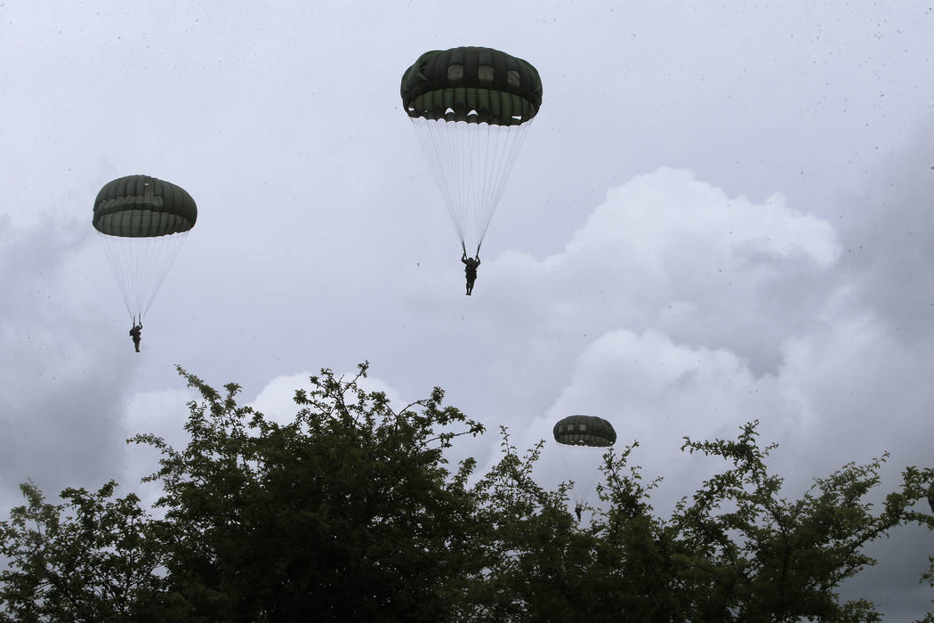 Parachutists jump from C-47 transport planes in Carentan, Normandy, France, Wednesday, June 5, ...