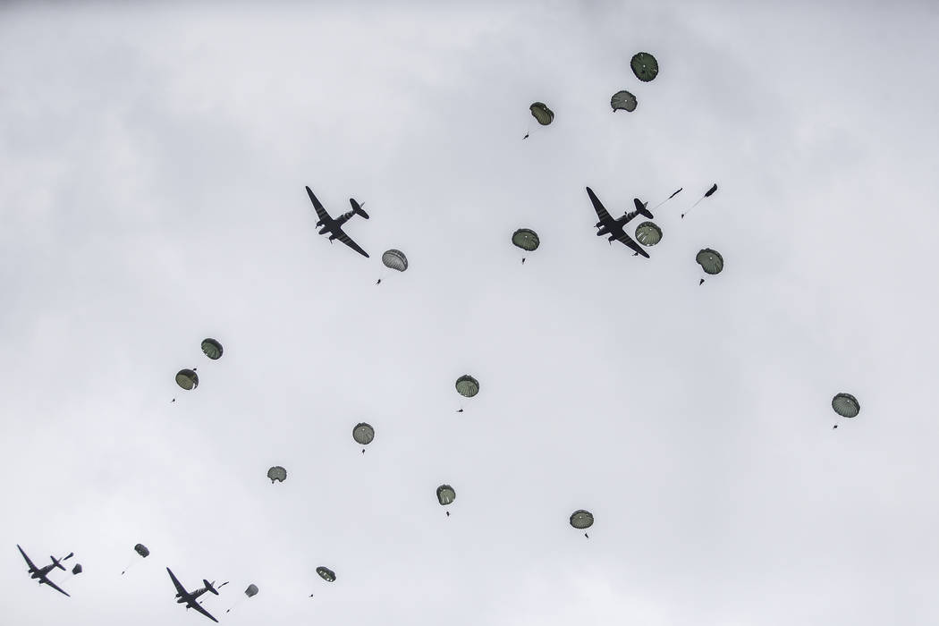 Parachutists jump from C-47 transport planes in Carentan, Normandy, France, Wednesday, June 5, ...