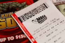 A Mega Millions lottery ticket rests on a shop counter. (AP Photo/John Minchillo)