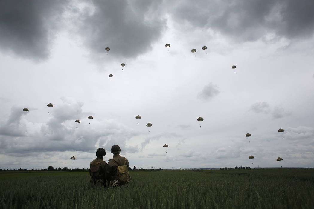World War II enthusiasts watch French and British parachutists jumping during a commemorative p ...