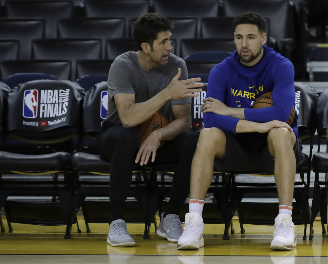 Golden State Warriors general manager Bob Myers, left, speaks with Klay Thompson during practic ...