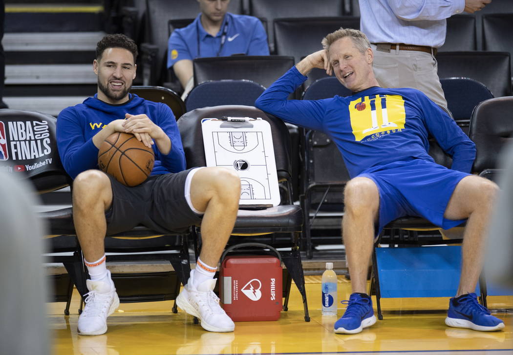 Golden State Warriors' Klay Thompson, left, and head coach Steve Kerr share a laugh during prac ...