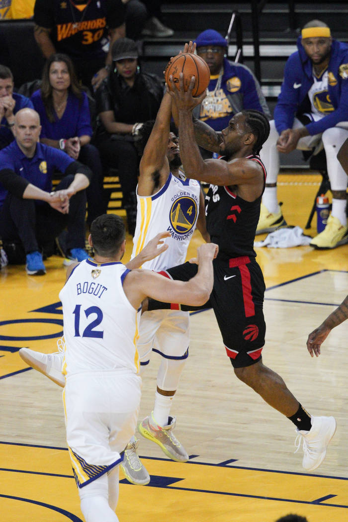 Toronto Raptors forward Kawhi Leonard, right, shoots against Golden State Warriors guard Quinn ...