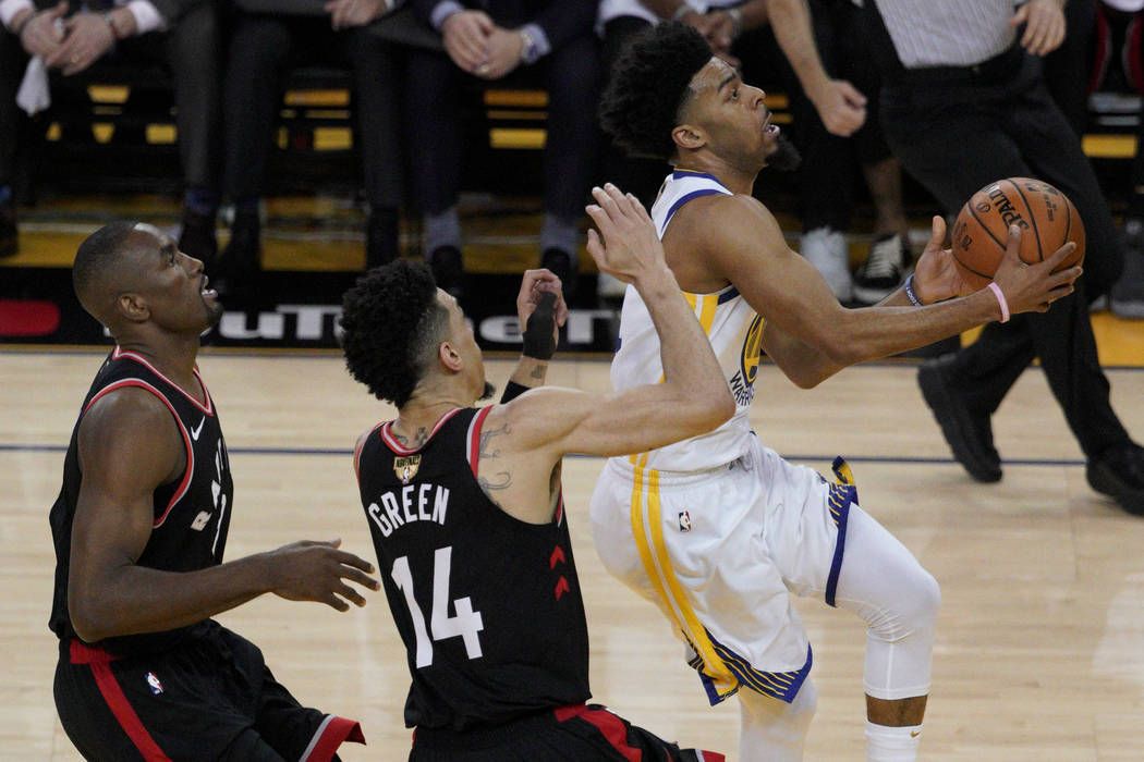 Golden State Warriors guard Quinn Cook, right, shoots against Toronto Raptors center Serge Ibak ...