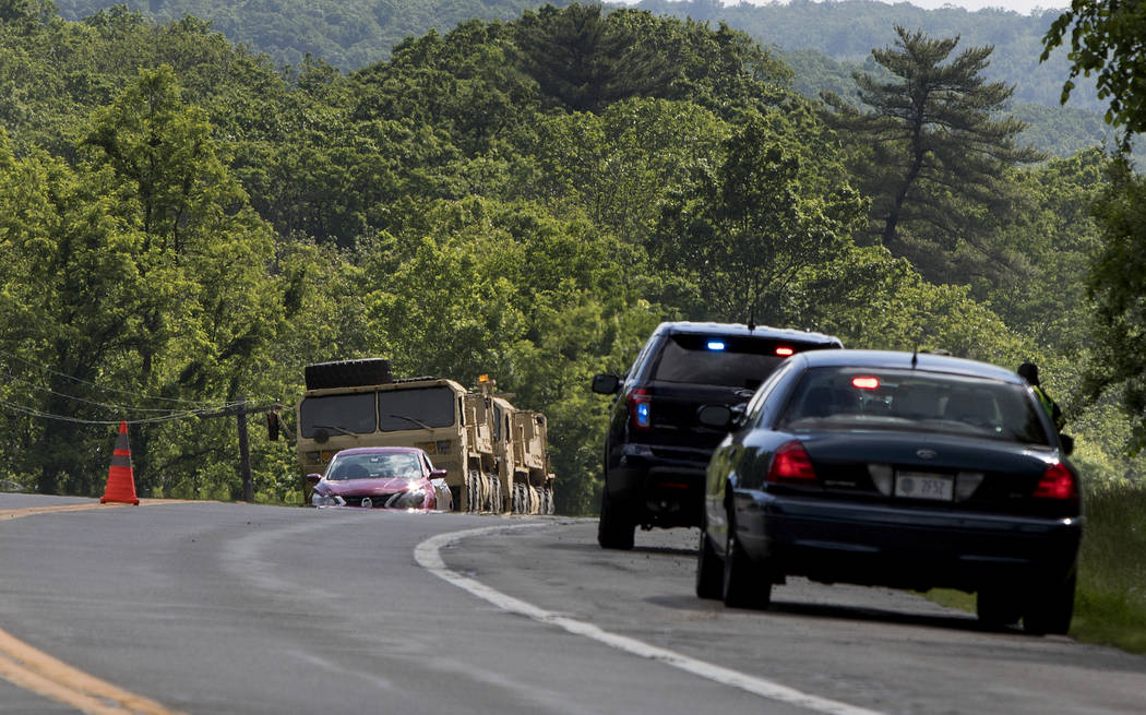 Military vehicles sit alongside Route 293 near the site where an armored personnel vehicle over ...