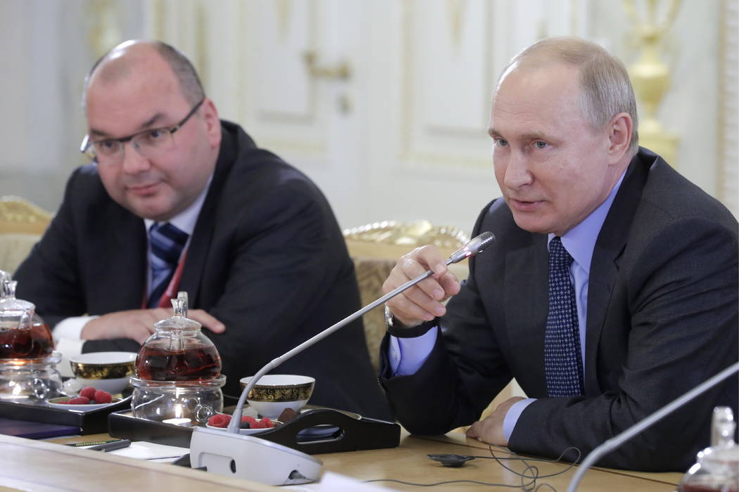 Russian President Vladimir Putin, right, speaks during a meeting with heads of world's leading ...