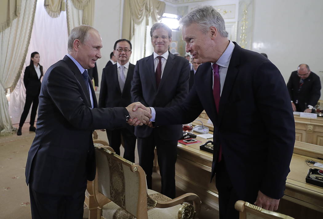 Russian President Vladimir Putin, left, shakes hands with Gary Pruitt, President and CEO of The ...