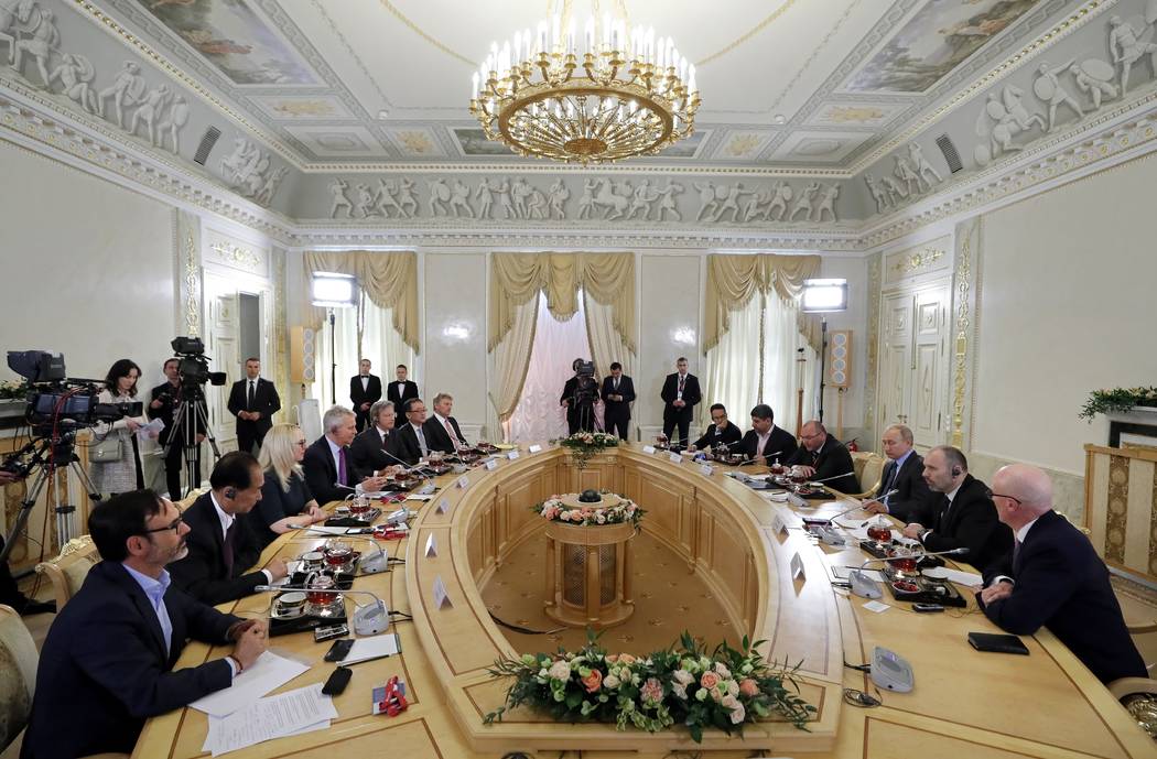 Russian President Vladimir Putin, third right, speaks during a meeting with heads of world's le ...