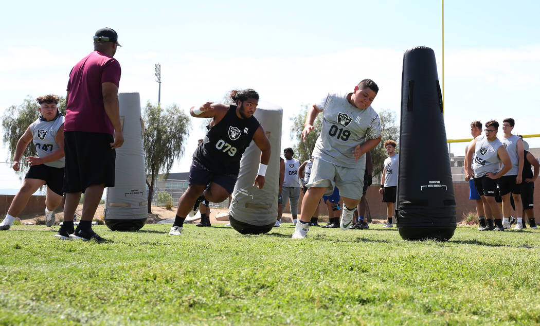 Leland Sparks, left, lead manager for Raiders football camp, watches as Clark County-area high ...