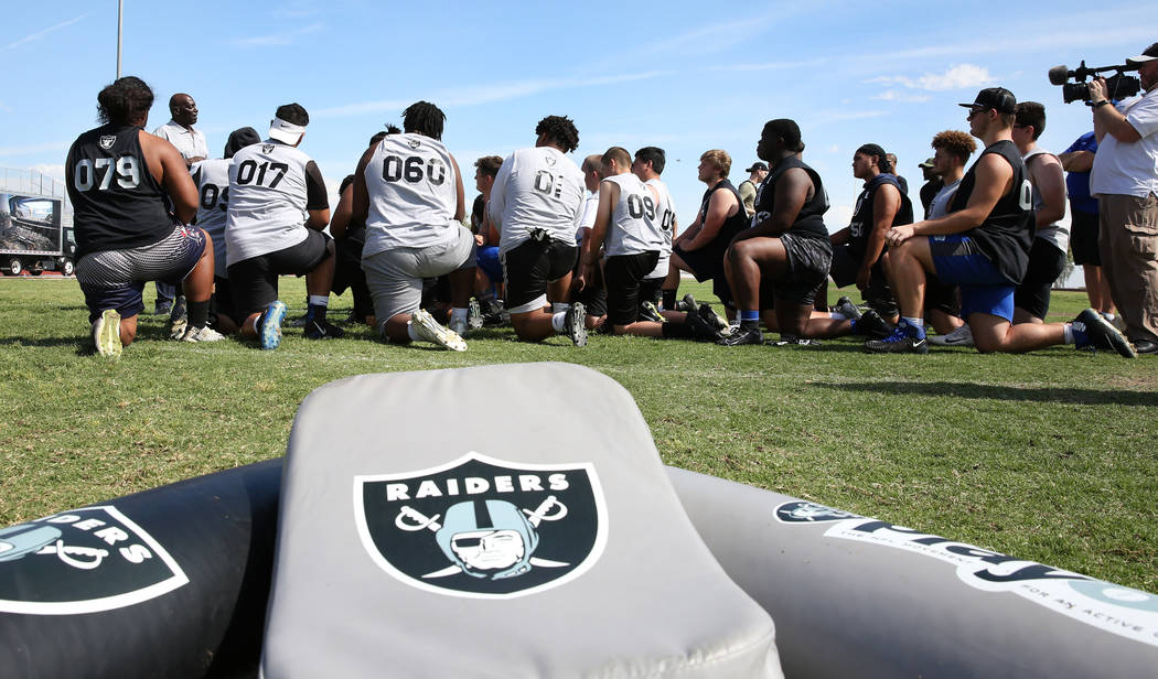 Clark County-area high school football players listen to Reggie Kinlaw, second left, a former ...