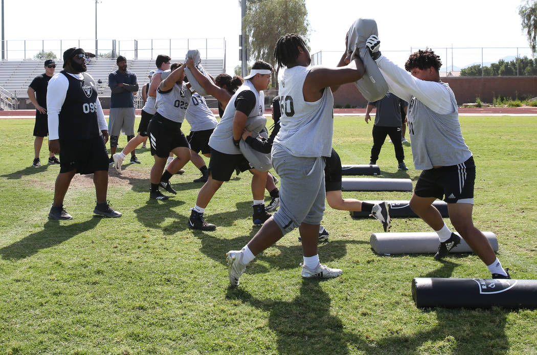 Former Faith Lutheran high school's offensive line coach De'Andre Nicholas, center, watches as ...