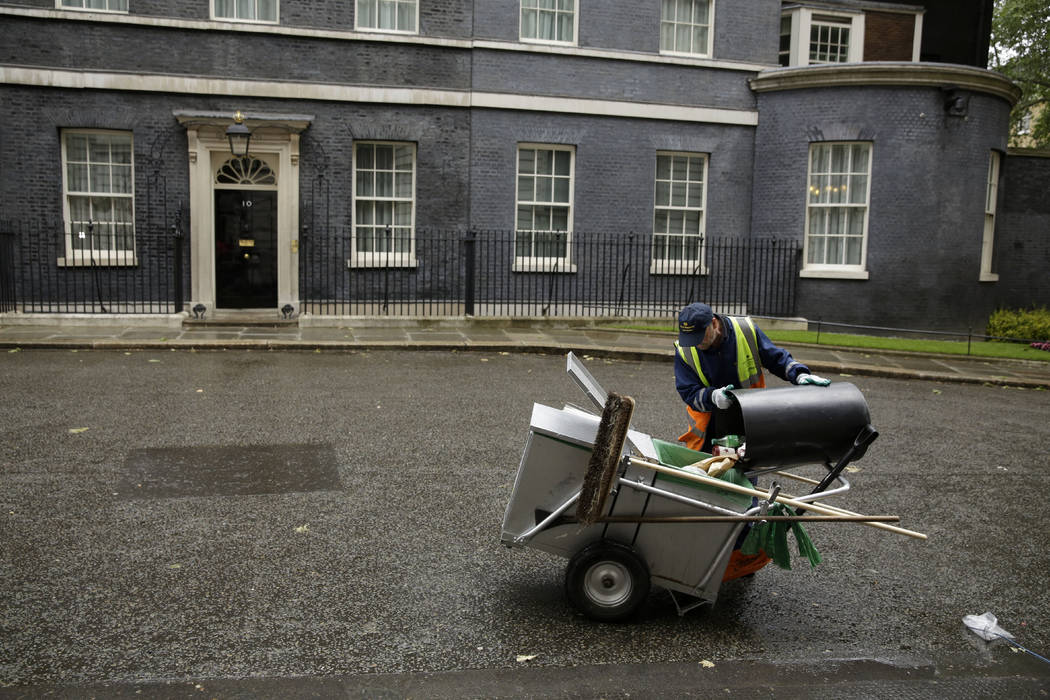 A street cleaner empties a rubbish bin in Downing Street, London, Friday, June 7, 2019. Prime M ...