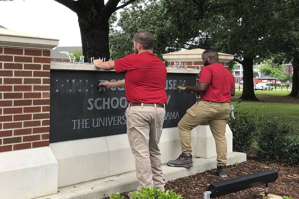 University of Alabama employees remove the name of Hugh F. Culverhouse Jr. off the School of La ...