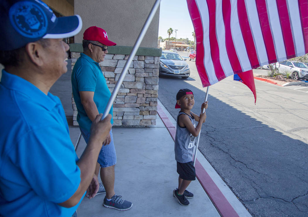 Jayden Rubalcaba, 6, waves the Filipino flag, with his grandfather, Joseph Dulay, 58, middle, a ...