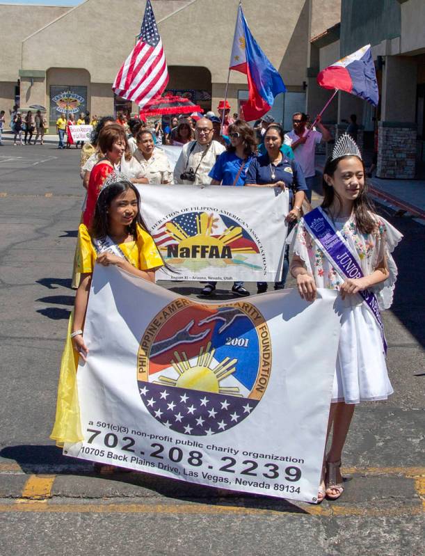 Sophia Natividad, 9, and Evelyn Henderson, 10, lead the front of the parade before the fourth a ...