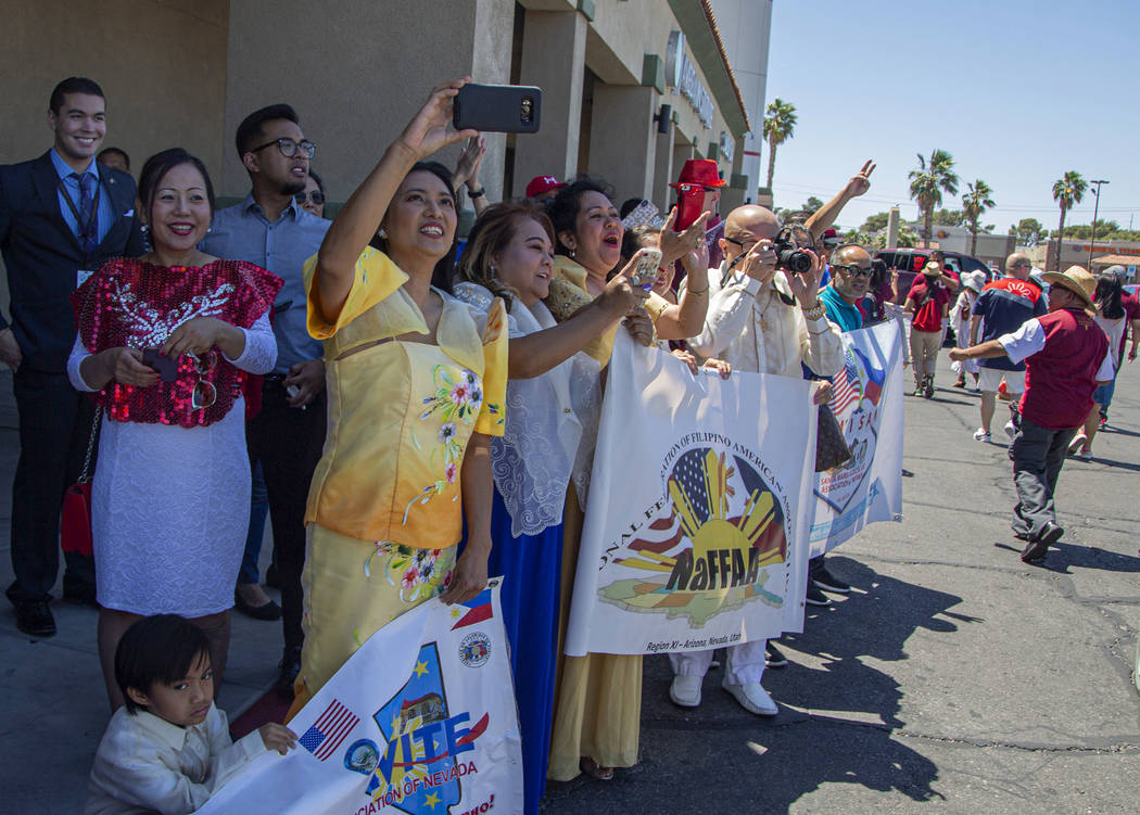 People wave and take photos during the annual celebration of the 121st Year of Philippine Indep ...