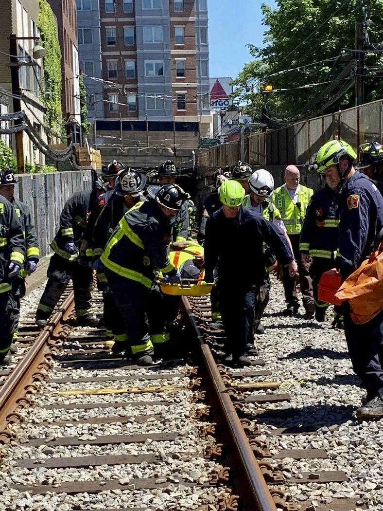 This photo provided by the Boston Fire Department, Firefighters and EMT personnel carry an inju ...