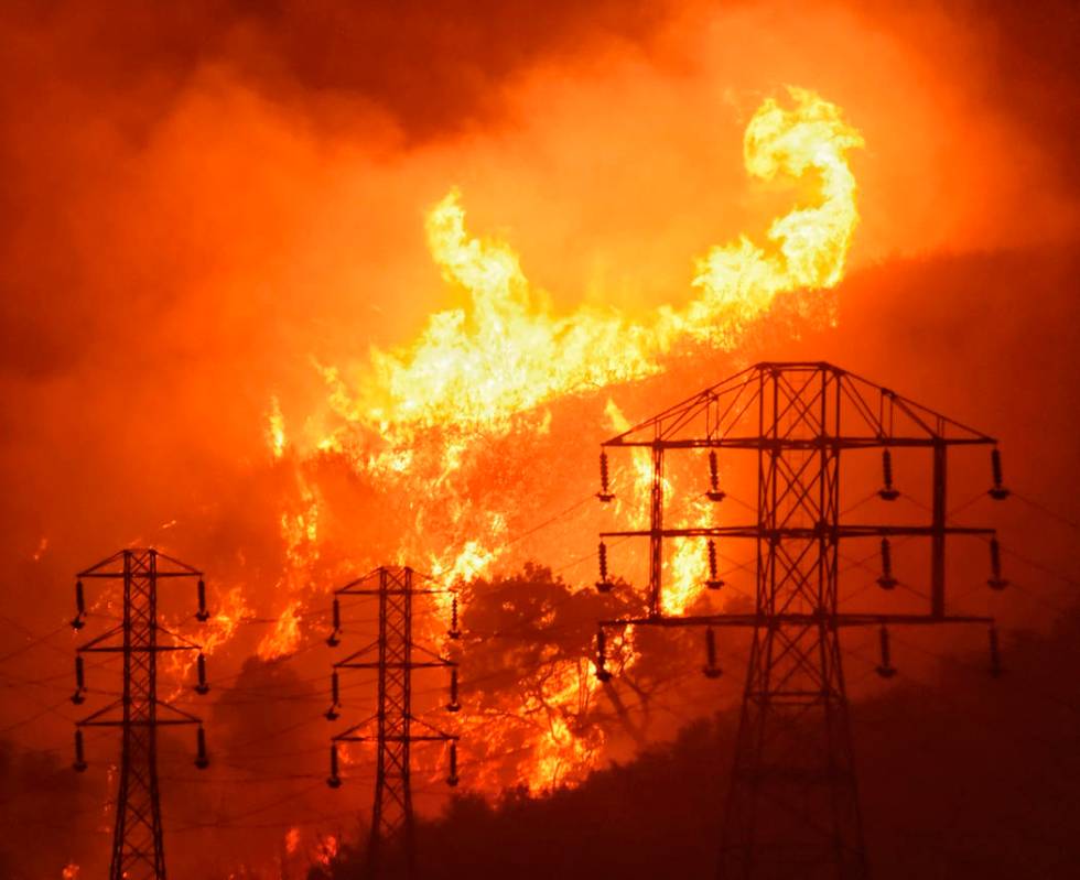 Flames burn near power lines in Sycamore Canyon near West Mountain Drive in Montecito, Calif., ...