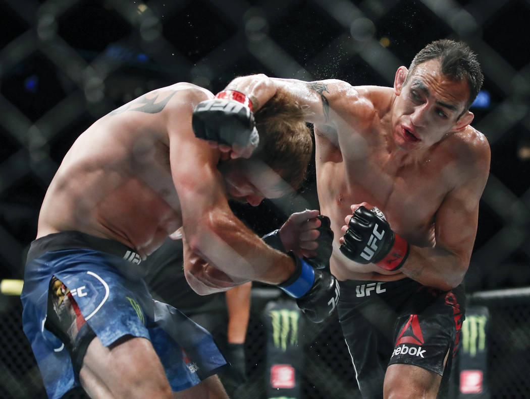 Tony Ferguson, right, punches Donald Cerrone, left, during their lightweight mixed martial arts ...