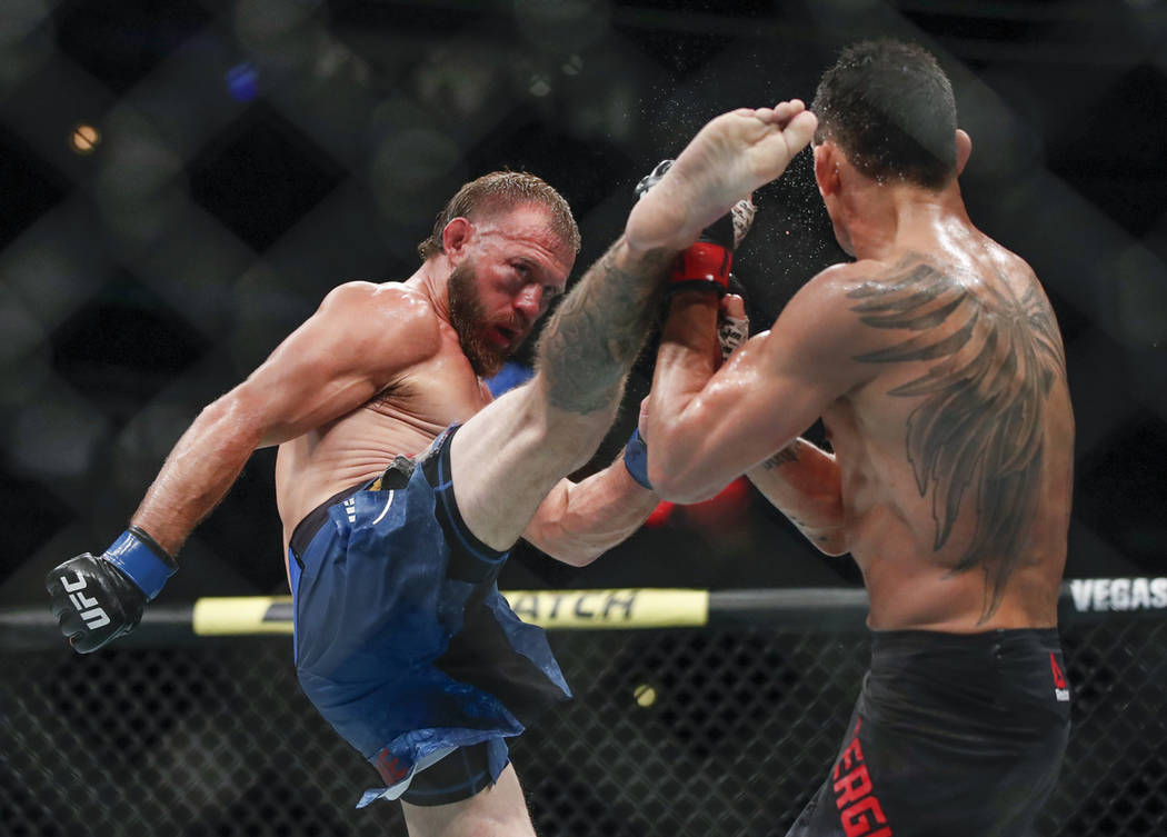 Donald Cerrone, left, kicks Tony Ferguson during their lightweight mixed martial arts bout at U ...