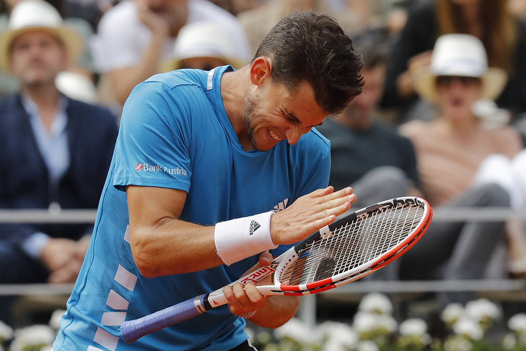 Austria's Dominic Thiem hits his racket after hitting a shot into the net in the second set aga ...