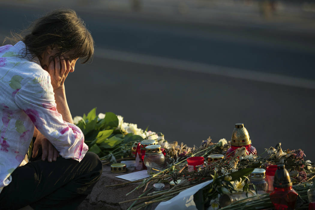 A woman visits a flower tributary at Margaret Bridge, the scene of the boat accident in Budapes ...