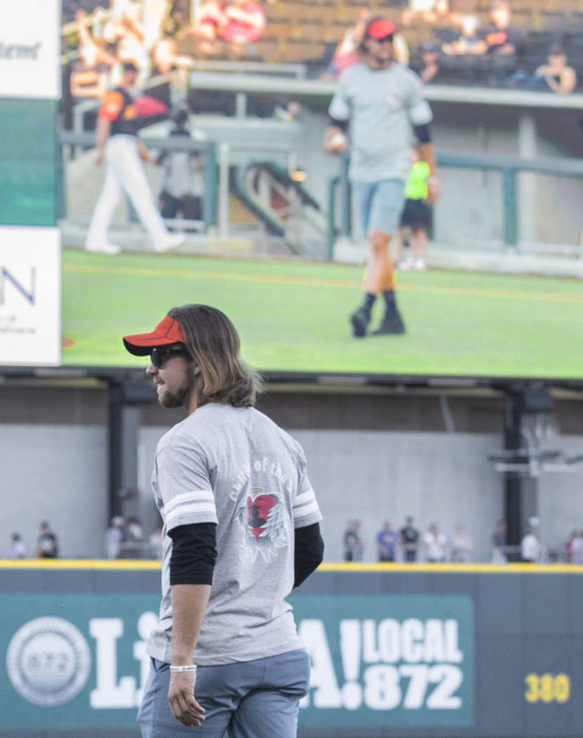 Kaden Manczuk walks onto the field to throw out the first pitch before the start of the Las Veg ...