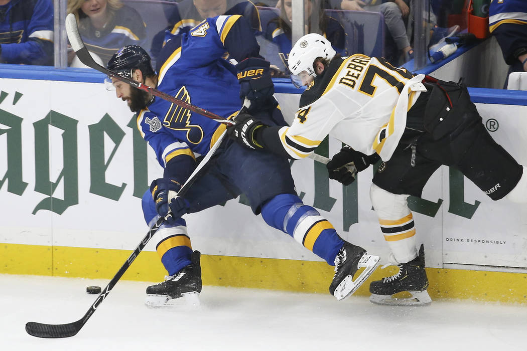 Boston Bruins left wing Jake DeBrusk (74) tries to stop St. Louis Blues defenseman Robert Bortu ...