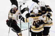 Boston Bruins left wing Jake DeBrusk (74) joins the celebration after Brandon Carlo, right, sco ...