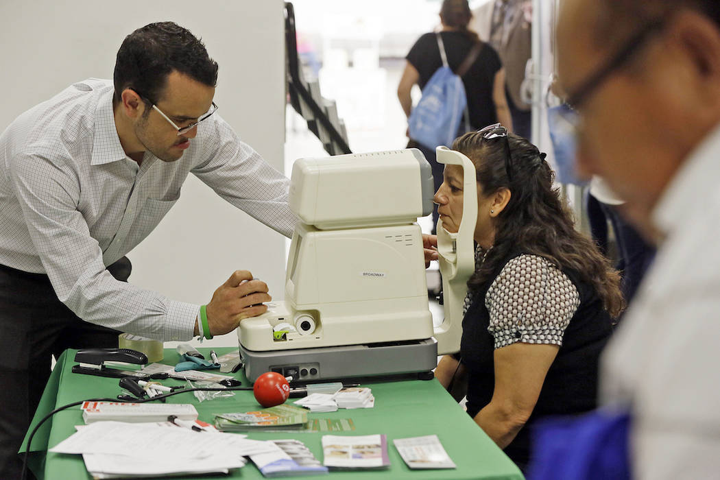 In this Oct. 1, 2013, file photo, Mexican national Rosa Guerra, right, gets a free eye exam dur ...